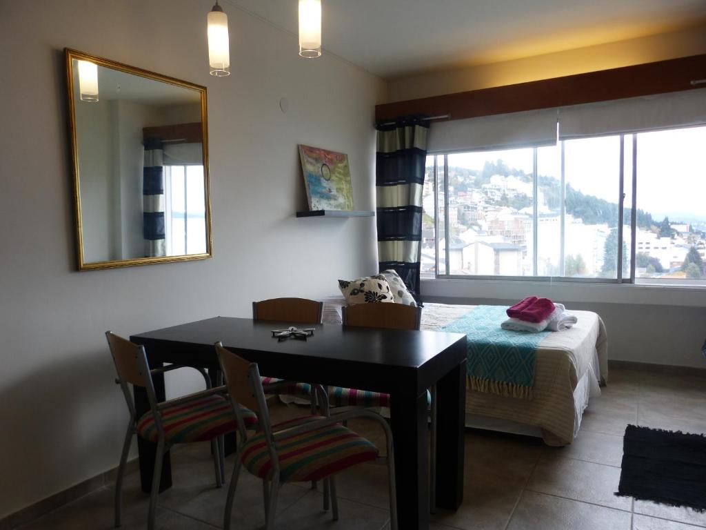 Habitación con mesa, cama y espejo. en Center 518 en San Carlos de Bariloche