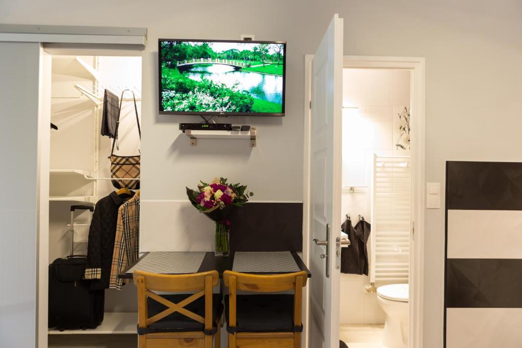 a living room with a table and a tv on a wall at Gold Basilica in Budapest