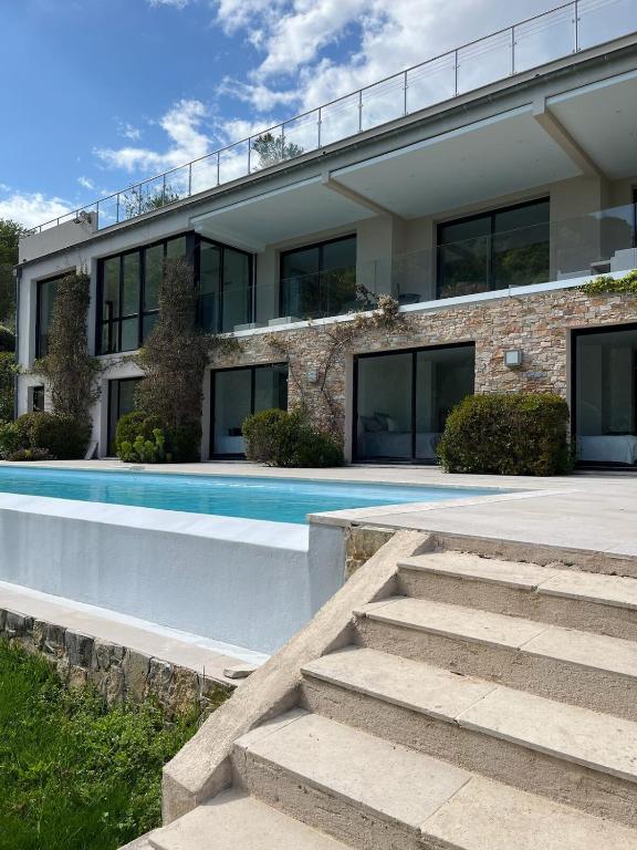 une maison avec une piscine devant dans l'établissement La perle - villa de luxe, à Villefranche-sur-Mer