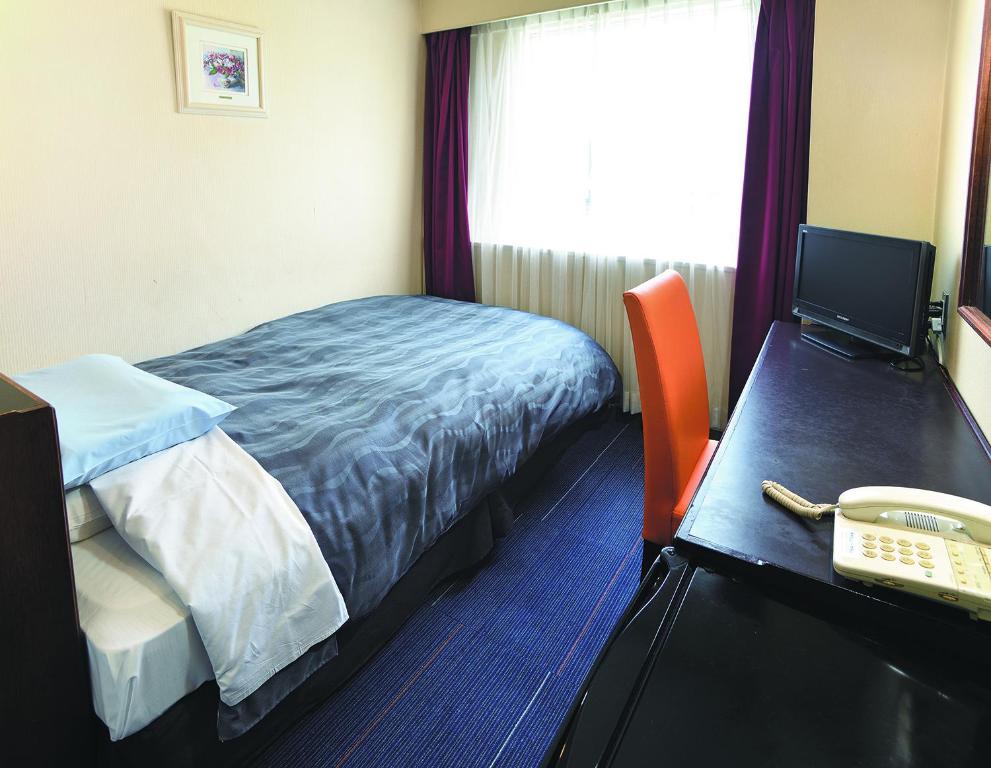 Postel nebo postele na pokoji v ubytování Bandai Silver Hotel