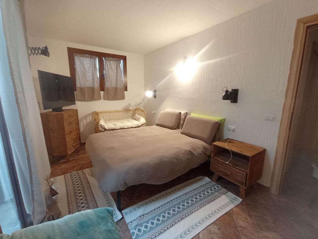 Un pequeño dormitorio con una cama y una mesa. en Da Elias, en Budoni
