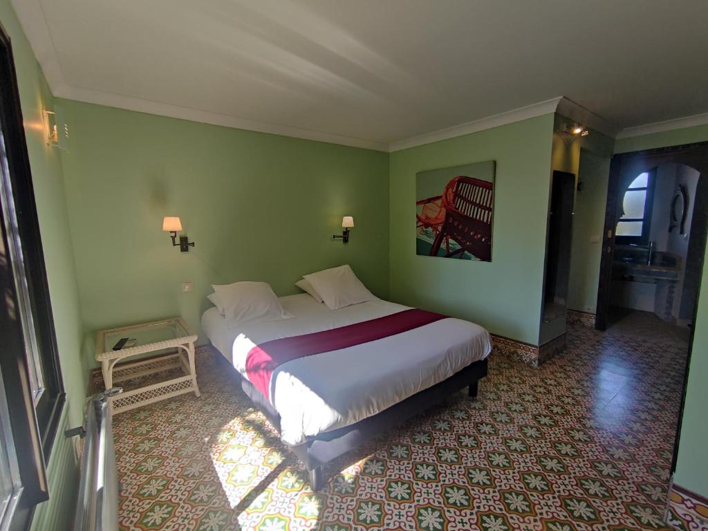 - une chambre avec un grand lit dans un mur vert dans l'établissement Chambre Emeraude, Riad 9 Couple only au village naturiste, au Cap d'Agde