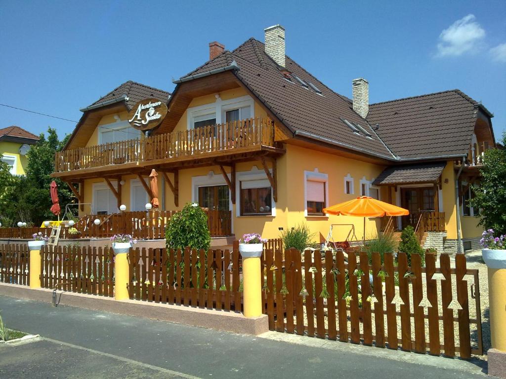 a house with a wooden fence in front of it at Apartman Siesta Bük in Bük