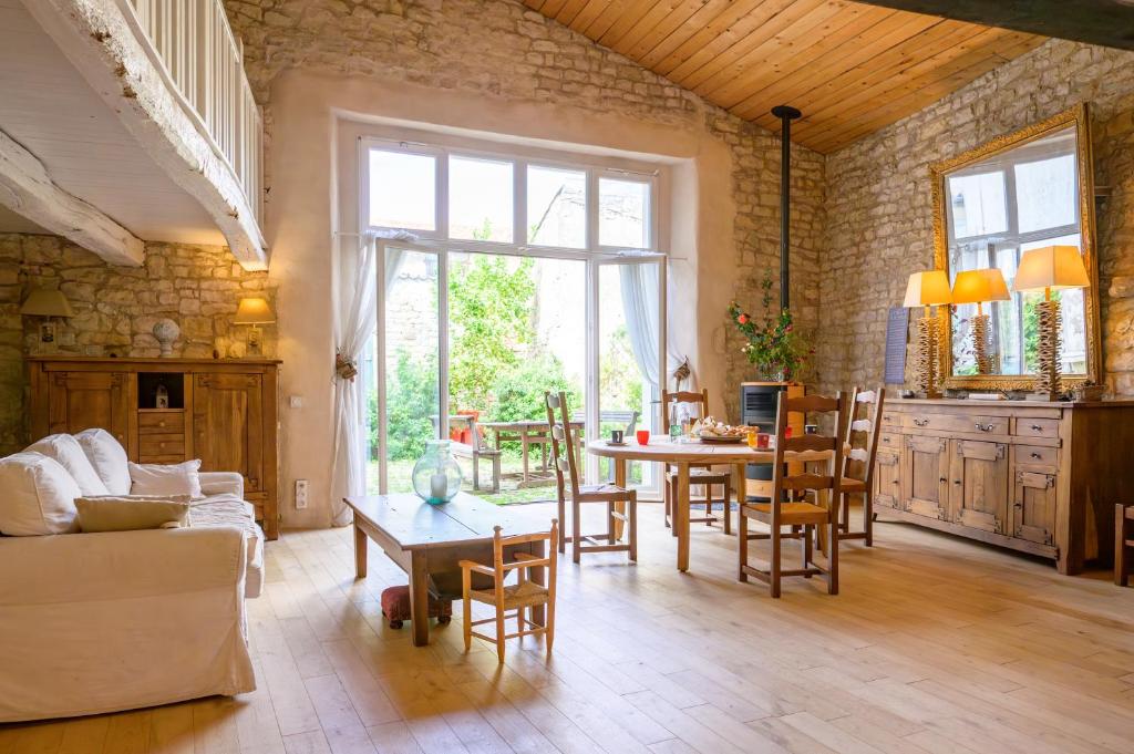 un salon avec un canapé et une table dans l'établissement Ancien chai réthais restauré en 2020, à Sainte-Marie de Ré