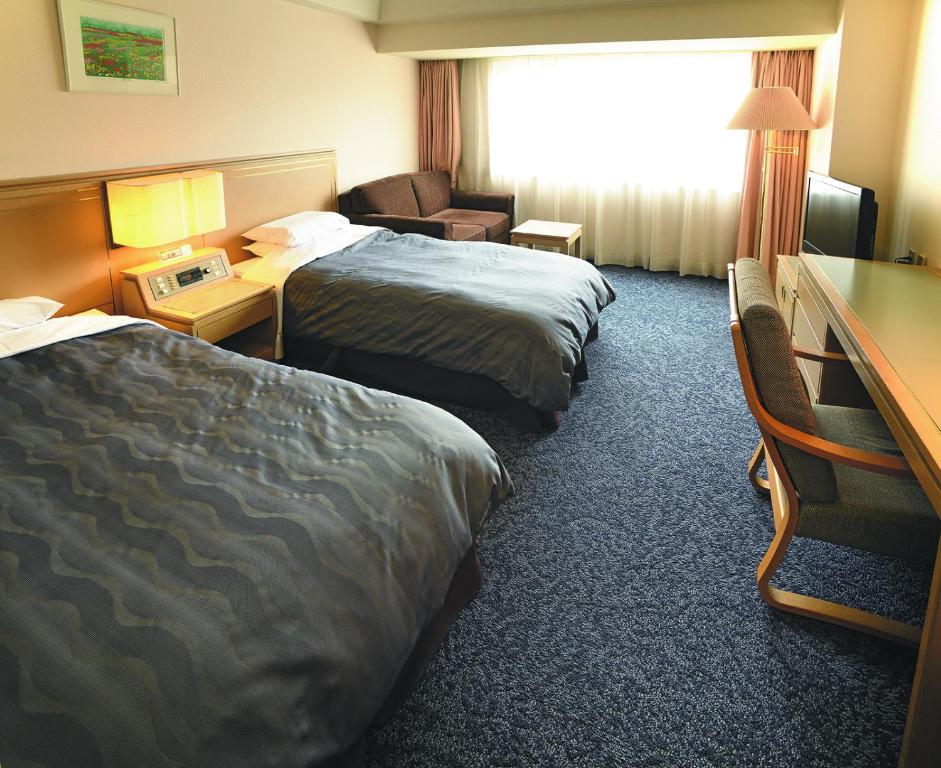 Postel nebo postele na pokoji v ubytování Bandai Silver Hotel