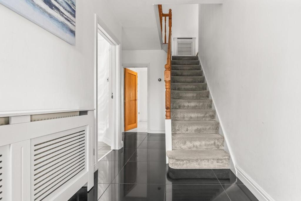 a staircase in a house with white walls and black tile floors at The Bishopsworth House in Bristol