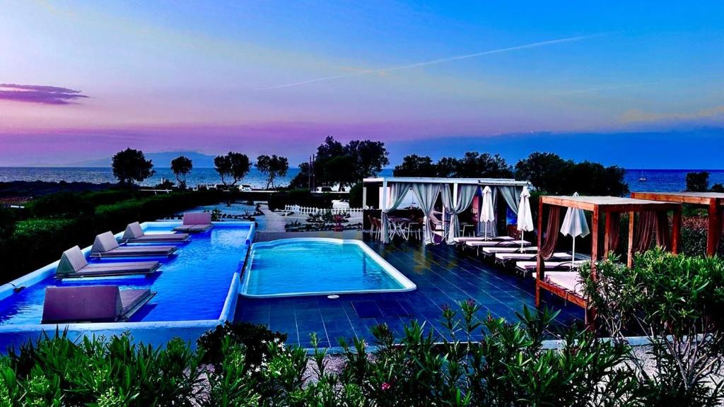una piscina con sedie a sdraio e un resort di Mare Nostrum Santo a Oia