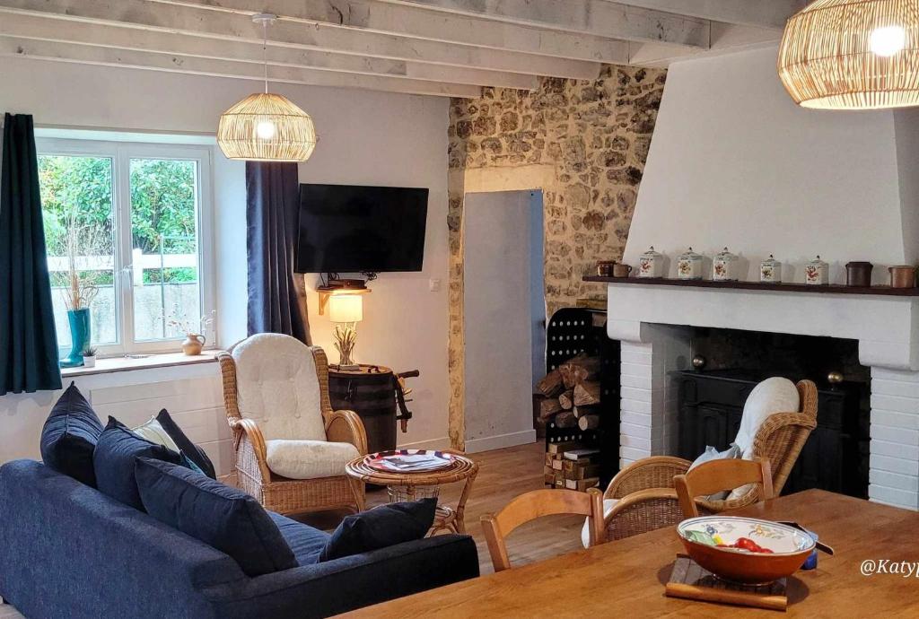 un salon avec un canapé bleu et une cheminée dans l'établissement Maison dans la Manche, à Saint-Malo-de-la-Lande