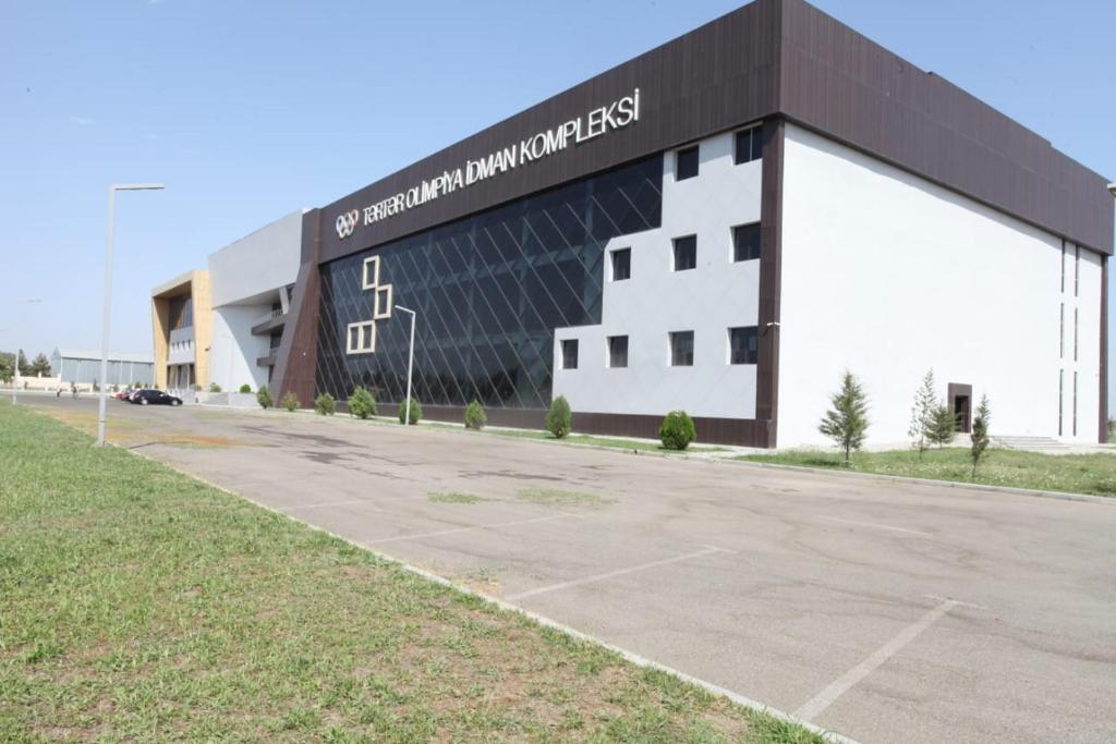 a large building with a sign on the side of it at Arena Hotel Tartar in Terter