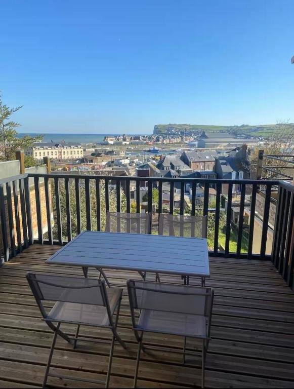 une table de pique-nique bleue et deux chaises sur une terrasse dans l'établissement Villa Valentine terrasse vue Mer & Falaises, au Tréport
