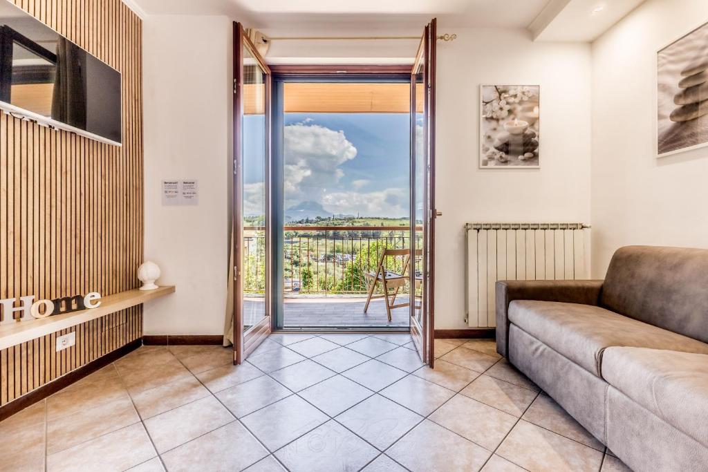 a living room with a couch and a sliding glass door at Relax House Fonte Nuova - Relax a pochi minuti da Roma in Fonte Nuova