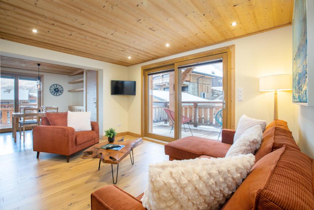un salon avec un canapé, des chaises et une table dans l'établissement 2 bedroom haven in enviable Morzine location, à Morzine