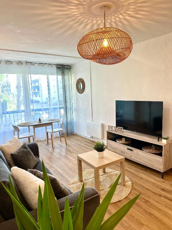 un salon avec un canapé, une télévision et une table dans l'établissement studio situé proche de la plage, à La Grande Motte