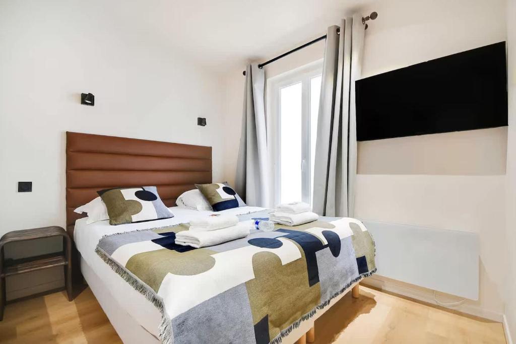 une chambre avec un grand lit avec une grande fenêtre dans l'établissement Les Halles - Grands Boulevards Renovated 3BR - 8P, à Paris