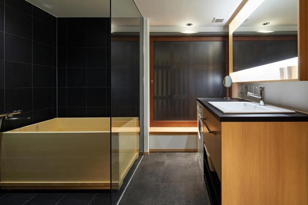 a bathroom with a bath tub and a sink at Enso Machiya in Kyoto