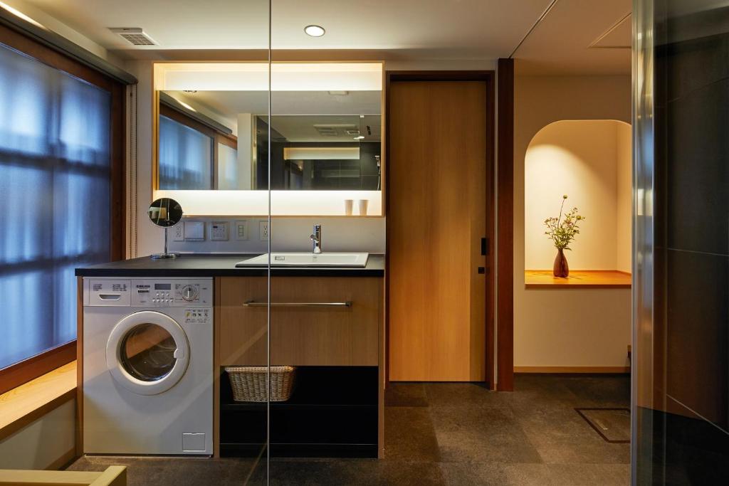 a laundry room with a washing machine and a sink at Enso Machiya in Kyoto