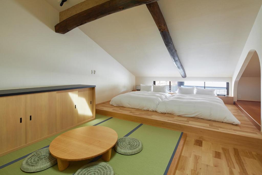 a bedroom with a large bed and a wooden table at Enso Machiya in Kyoto