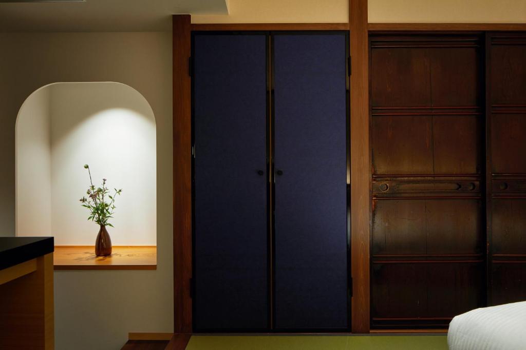 a bedroom with a closet and a blue door at Enso Machiya in Kyoto