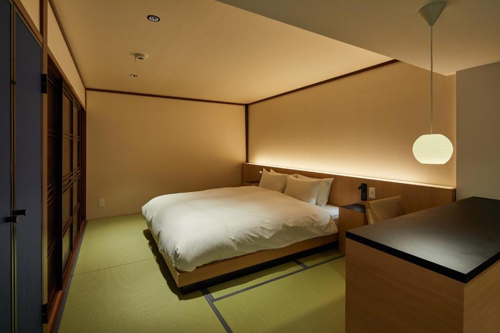 a small bedroom with a bed and a desk at Enso Machiya in Kyoto