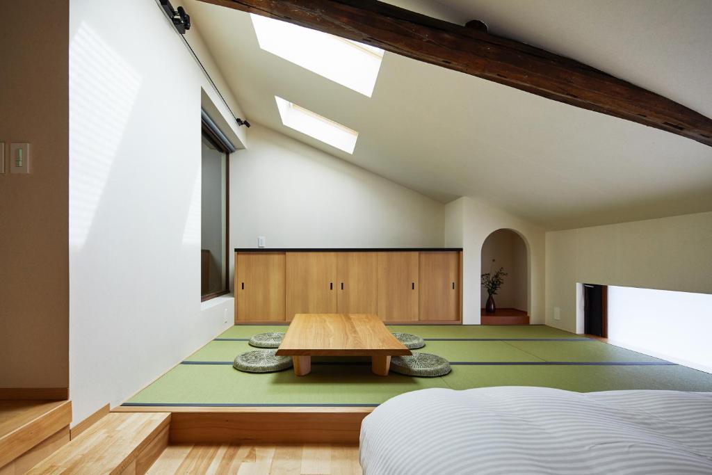 a bedroom with a table in the middle of a room at Enso Machiya in Kyoto
