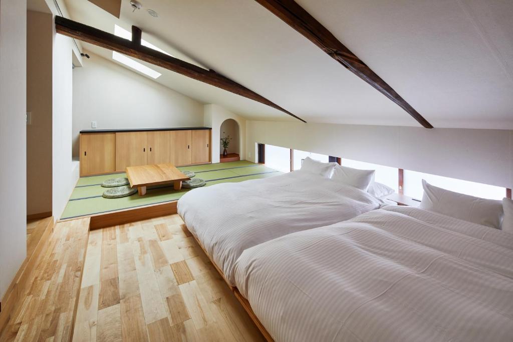 a large bedroom with two beds and a table at Enso Machiya in Kyoto