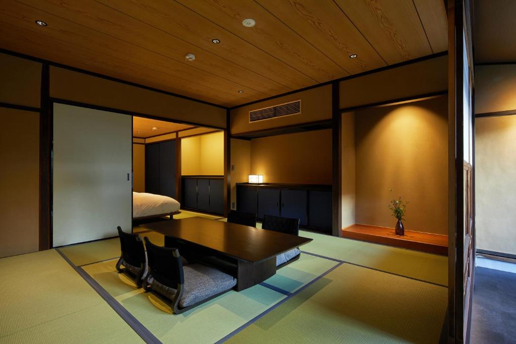 a room with a table and chairs and a bed at Enso Machiya in Kyoto