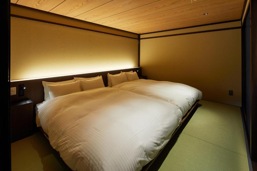 a large white bed in a small room at Enso Machiya in Kyoto