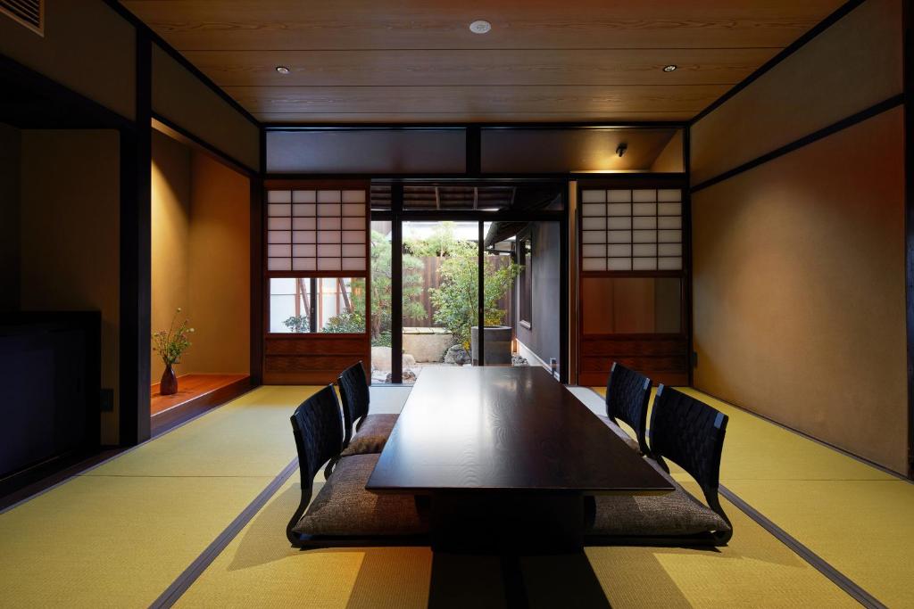 a dining room with a long table and chairs at Enso Machiya in Kyoto