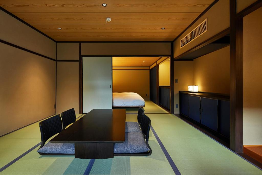 a dining room with a table and chairs and a bed at Enso Machiya in Kyoto