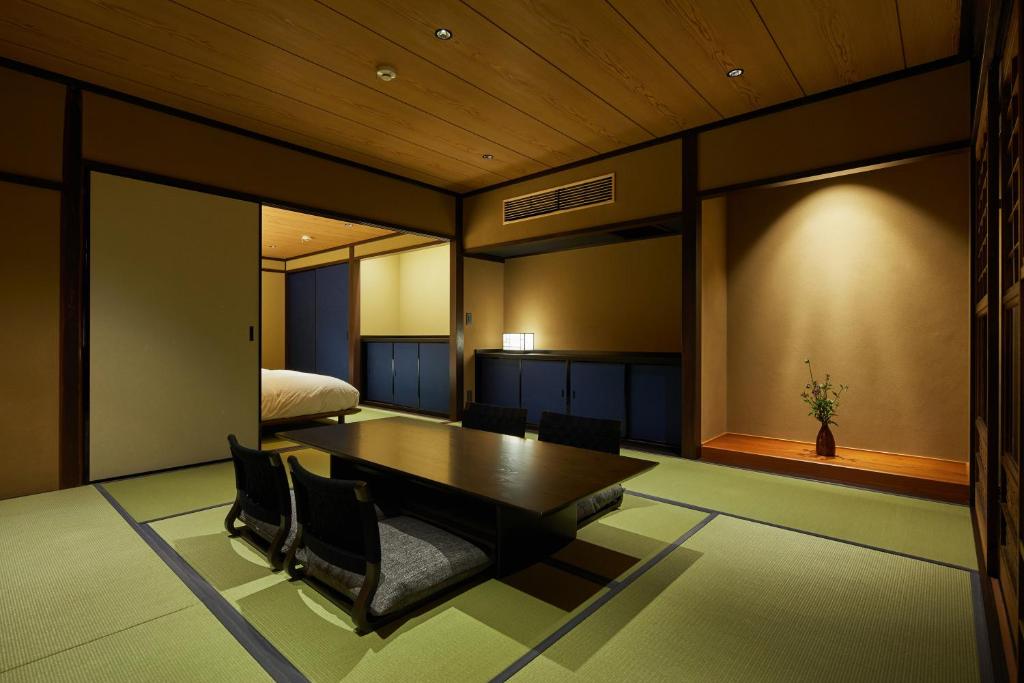 a room with a table and chairs and a bed at Enso Machiya in Kyoto