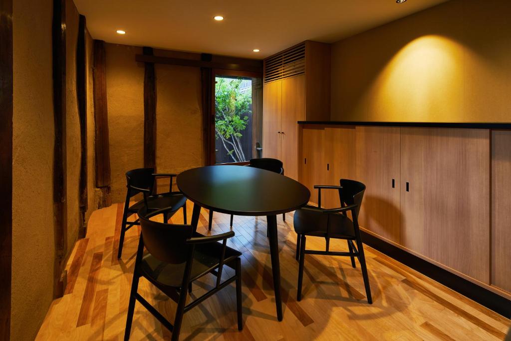 a dining room with a black table and chairs at Enso Machiya in Kyoto