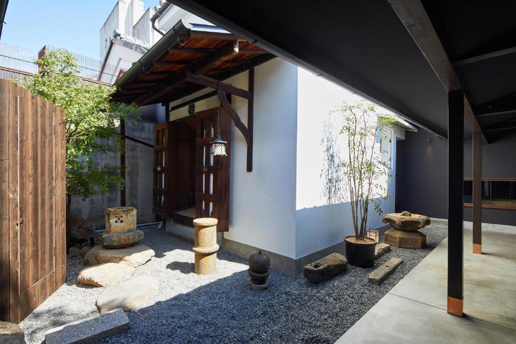 a house with a courtyard with trees and rocks at Enso Machiya in Kyoto