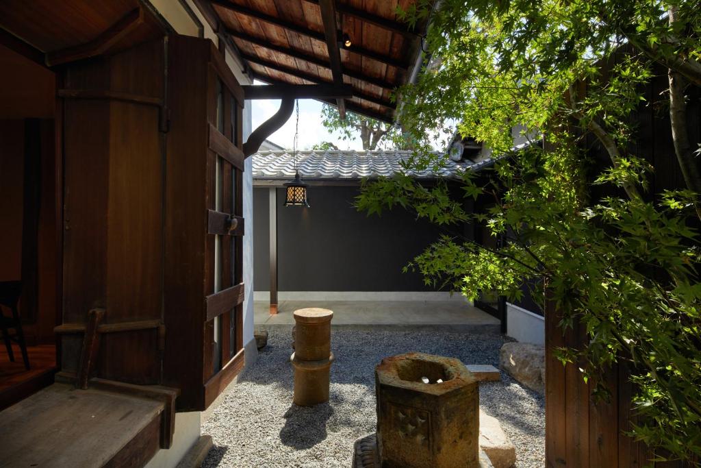 a courtyard of a building with a bench and trees at Enso Machiya in Kyoto