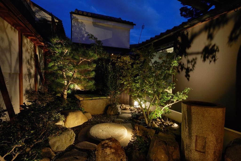 a small garden with rocks and trees in front of a building at Enso Machiya in Kyoto
