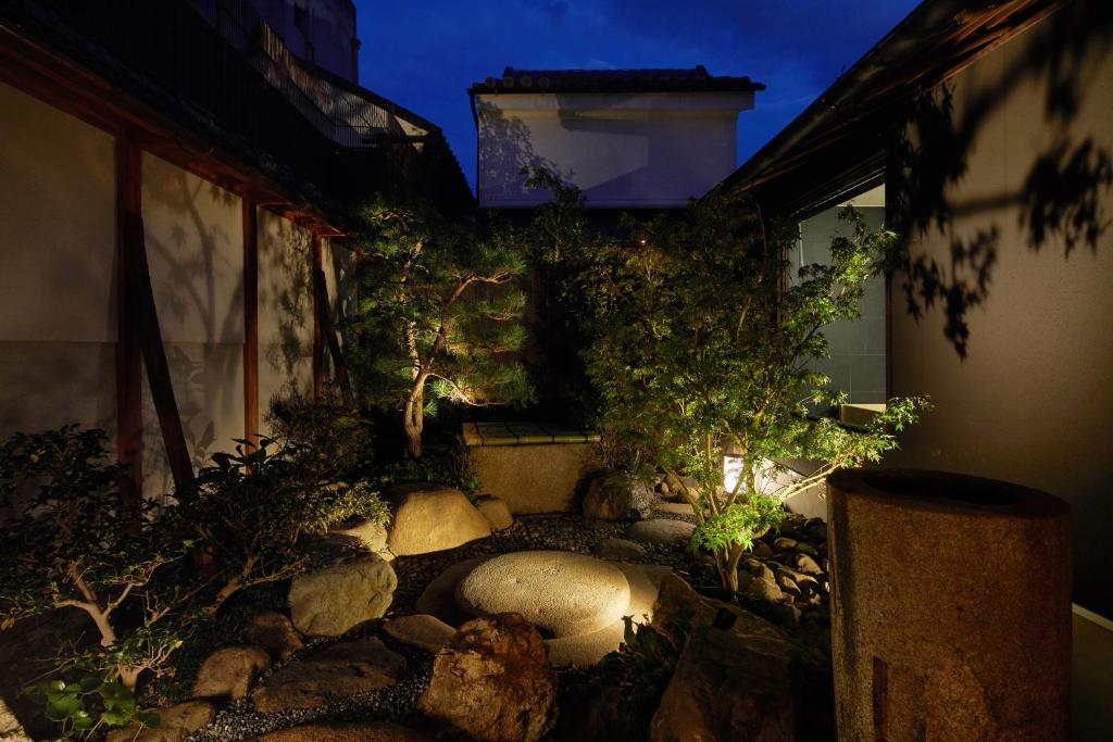 a garden with rocks and trees in front of a building at Enso Machiya in Kyoto