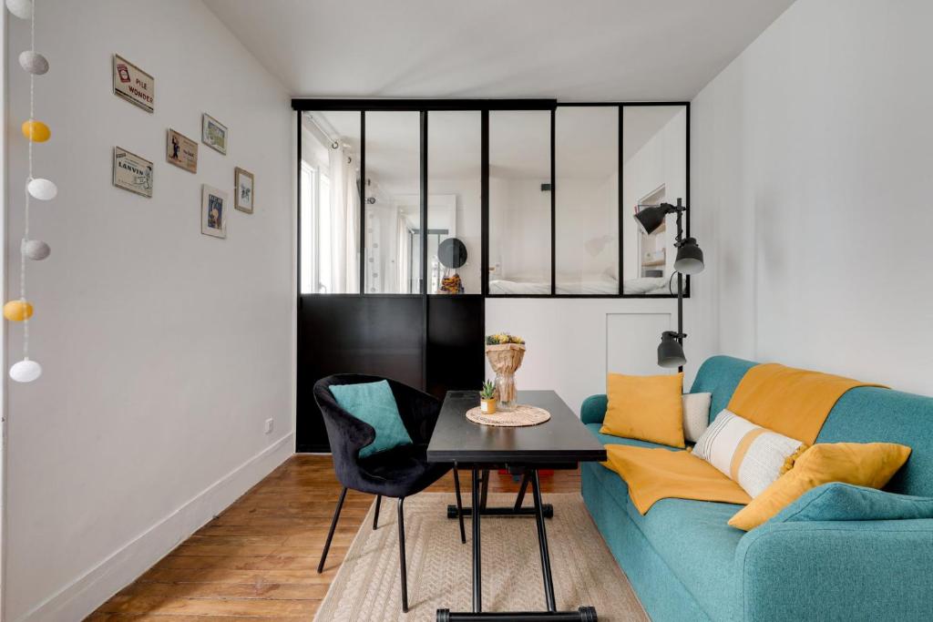 un salon avec un canapé bleu et une table dans l'établissement Mon Précieux, à Paris