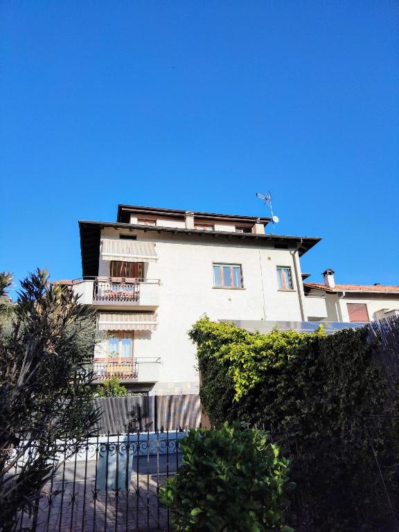 a white building with a fence in front of it at La Mansardina in Menaggio