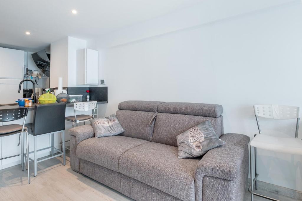 un salon avec un canapé et une cuisine dans l'établissement Cros de Cagnes 2 pièces Rev001, à Cagnes-sur-Mer