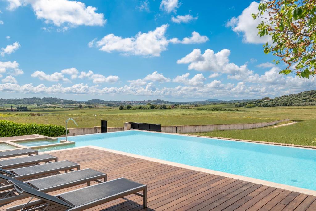 een zwembad met stoelen en een houten terras bij Dalt Son Morro in Santa Margalida