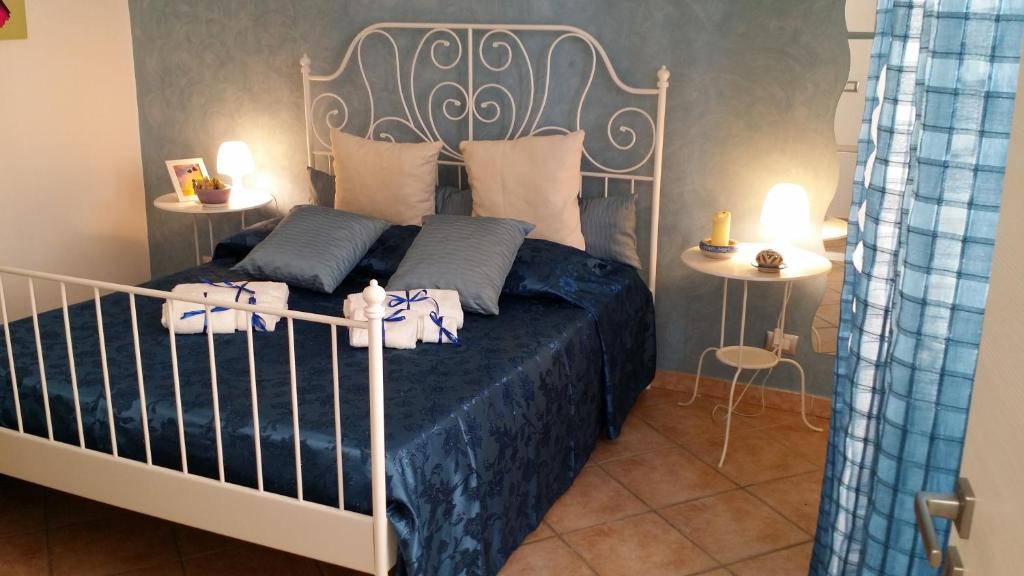 a bedroom with a bed with blue sheets and pillows at La Scaletta in Agrigento