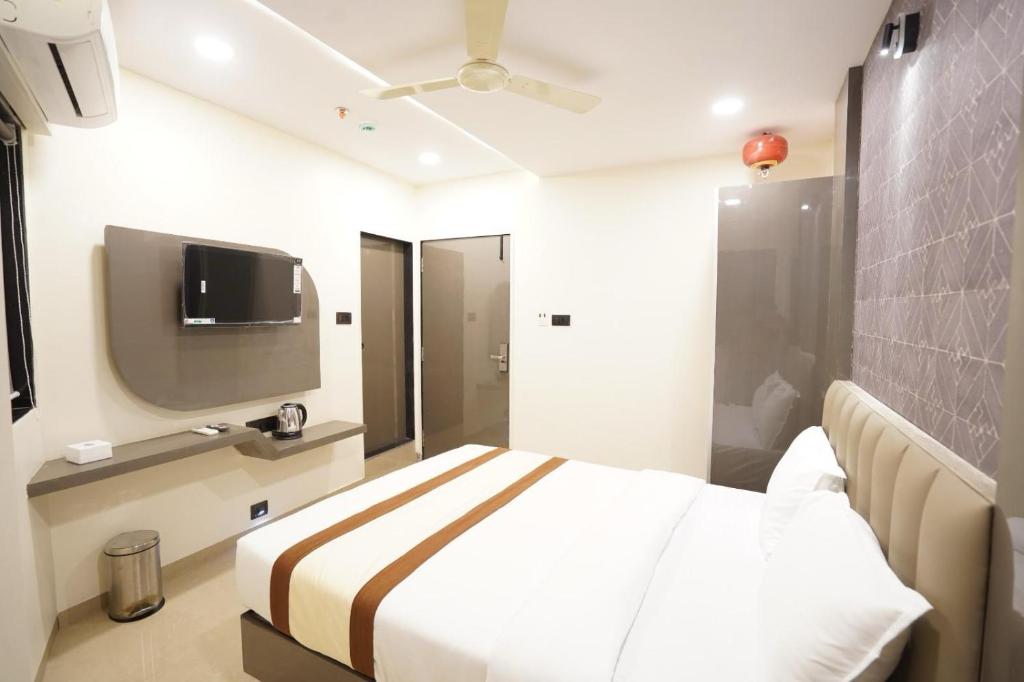 a hotel room with a bed and a flat screen tv at Hotel Lancaster in Mumbai