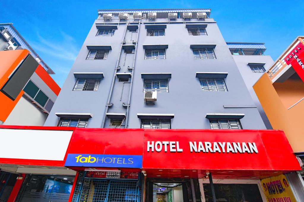 kolkataにあるHotel Nの正面に赤い看板があるホテルナラヤナンダンの建物