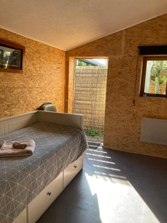 a bedroom with a bed and a large window at Studio avec terrasse et parking au Mans in Le Mans