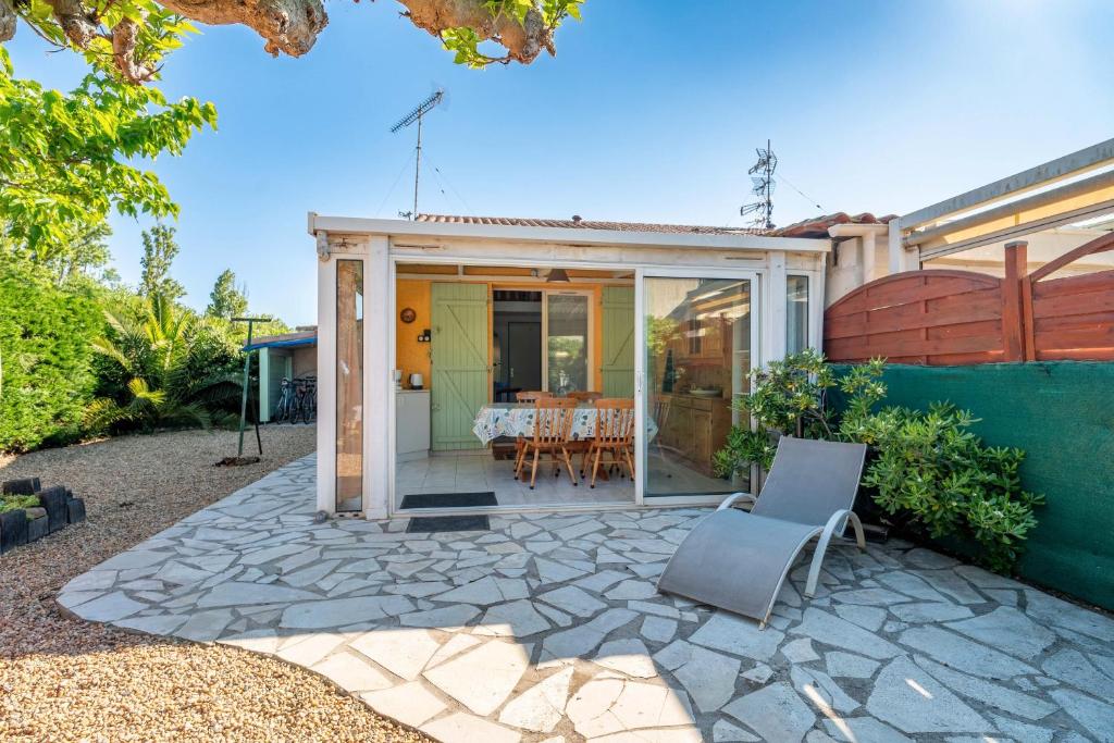 ヴァンドルにあるMini Villa jumelée Hameau du Soleilのパティオ(テーブル、椅子付)が備わるアパートメントです。