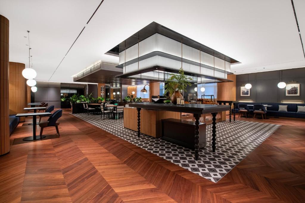 a lobby of a hotel with tables and chairs at Intercity Hotel Shanghai City Center - Free Mini Bar in Shanghai