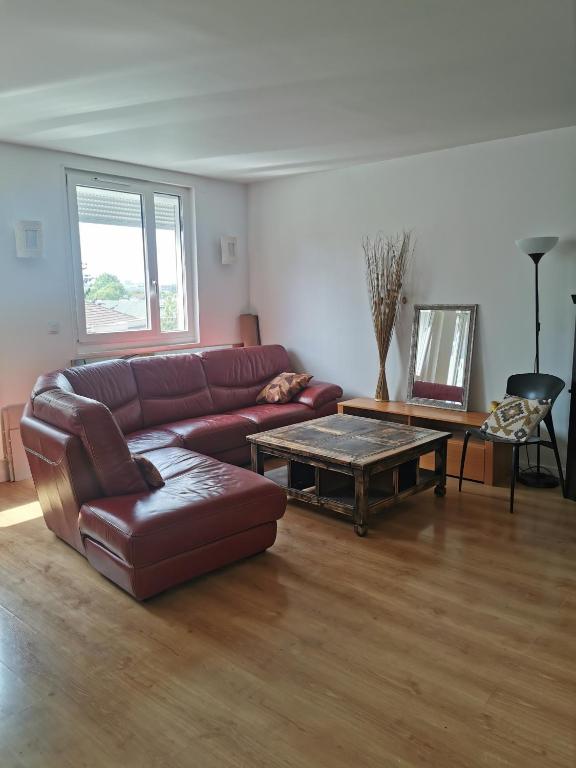 un salon avec un canapé et une table basse dans l'établissement Les coquelicots, à Romainville