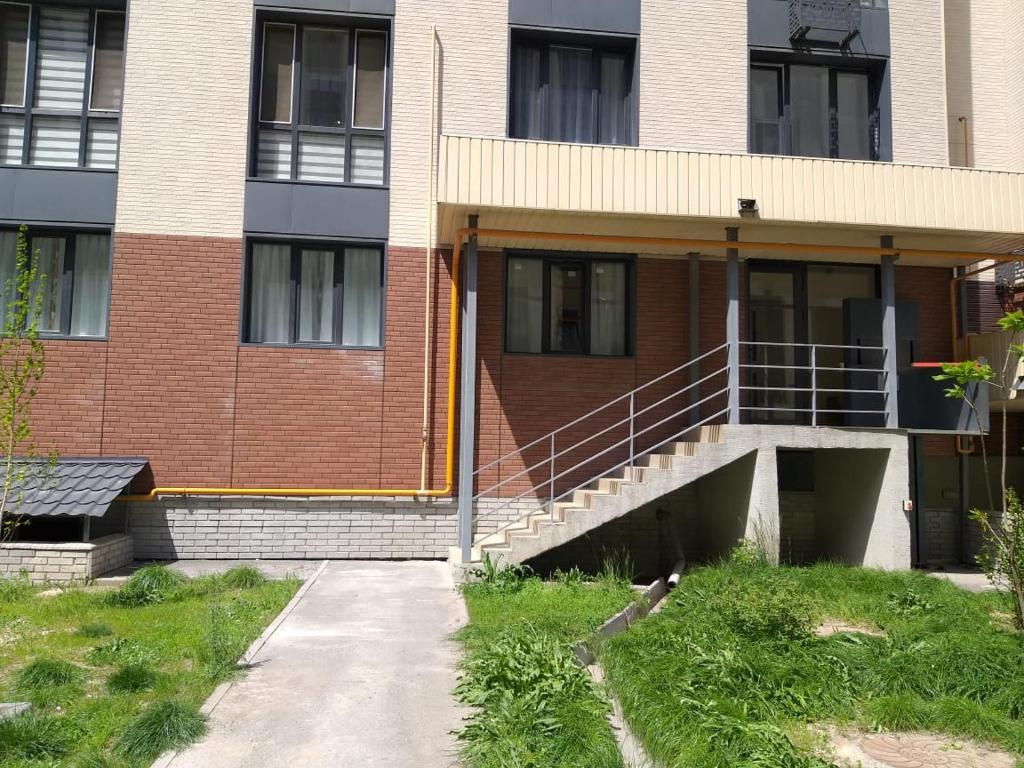 a brick building with a staircase in front of it at Hostel House ЖК Ожет in Almaty
