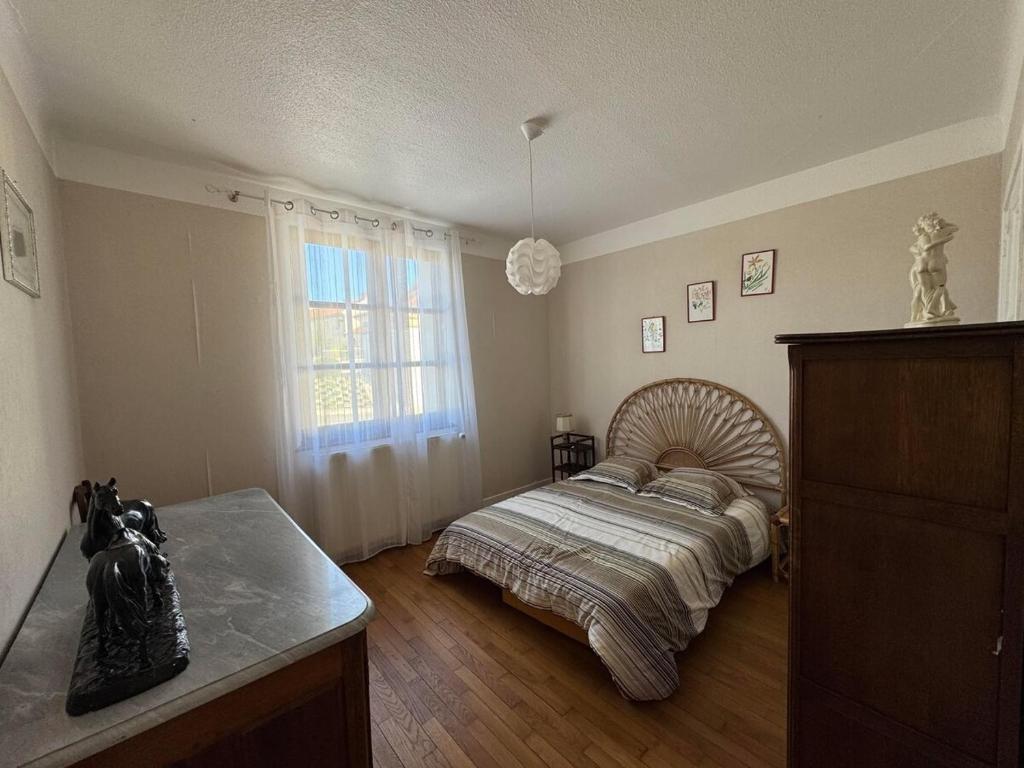 ein Schlafzimmer mit einem großen Bett und einem Fenster in der Unterkunft Le nid d'Hirondelle in Vanault-les-Dames