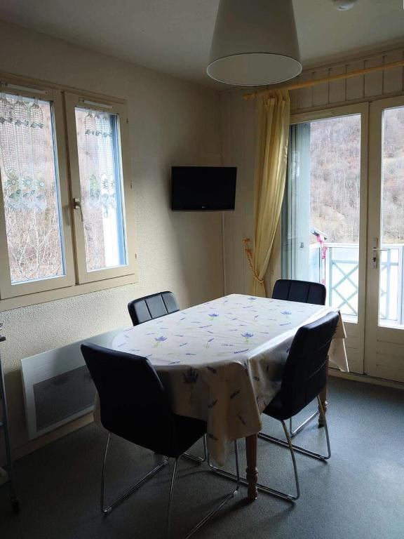 une pièce avec une table, des chaises et des fenêtres dans l'établissement Résidence Balcons De Bareges - Appartement avec balcon et parking MAE-8344, à Barèges
