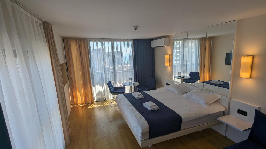 a bedroom with a large bed and a large window at Orbi City, block C in Batumi